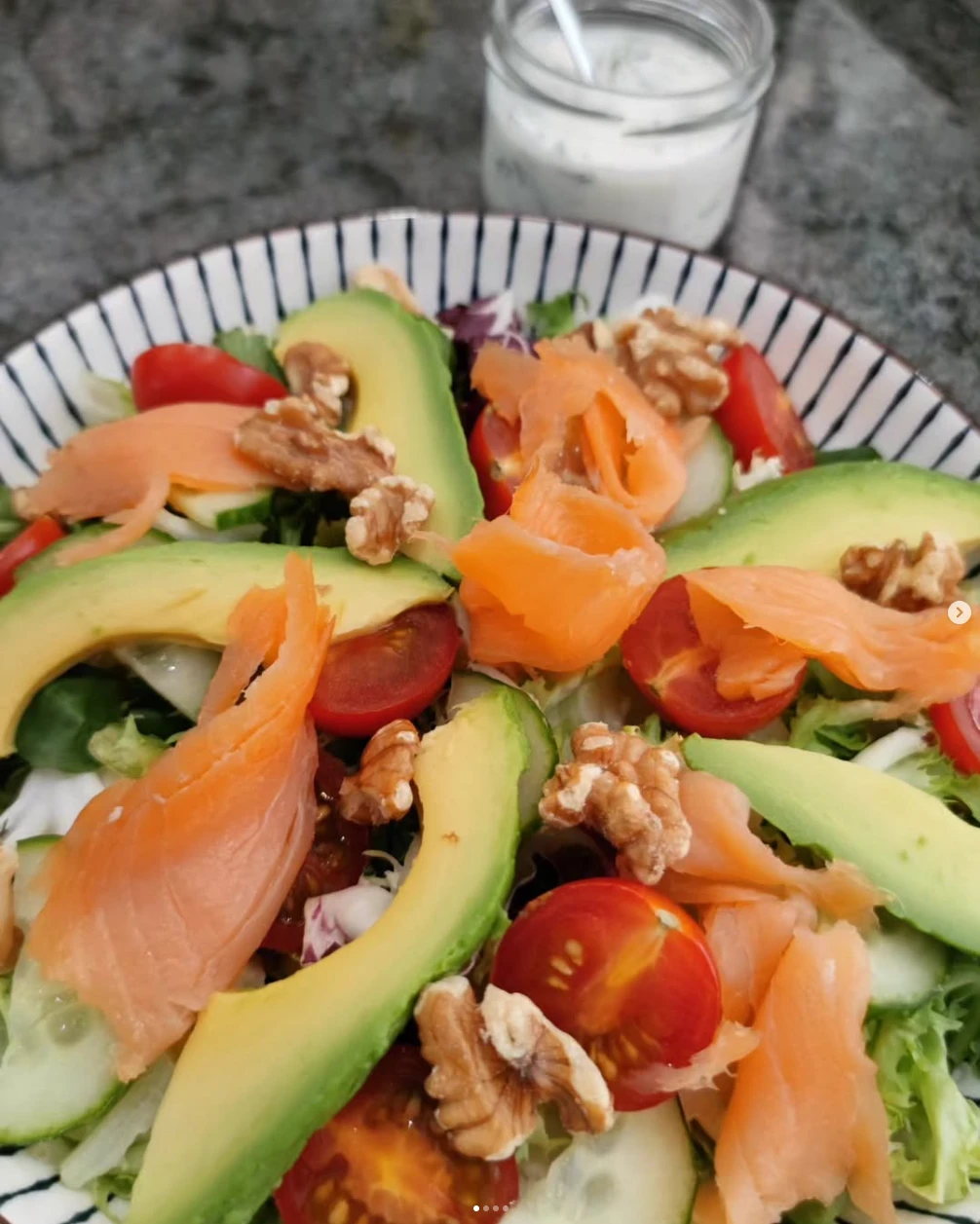 Ensalada con aguacate, tomate, nueces y láminas de salmón